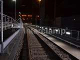 nighttime view of railway with Interclamp handrail system and pedestrian barrier 